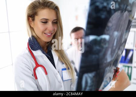 Donna medico guarda un'immagine radiologica insieme al paziente. Foto Stock