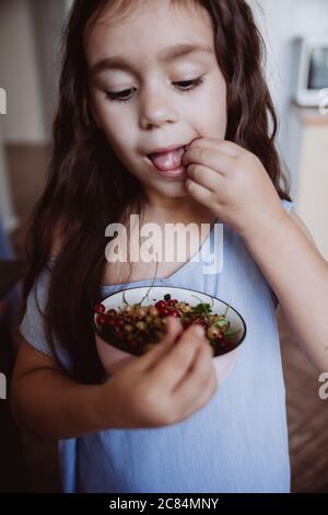 Carino bambina mangiare curry in cucina. Stile di vita estivo, concetto vegano. Foto Stock