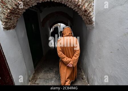 Marocco, Tetouan: Scena dalla vita quotidiana con gli abitanti della medina, registrato come patrimonio dell'umanità dell'UNESCO. Uomo anziano con un Bournou marrone Foto Stock