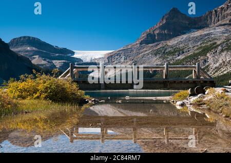 Un ponte pedonale in legno vicino al lago Bow, Alberta, Canada. Foto Stock