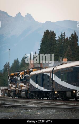 Il treno Rocky Mountaineer con il Monte Girouard dietro, stazione ferroviaria di Banff, Alberta, Canada. Foto Stock