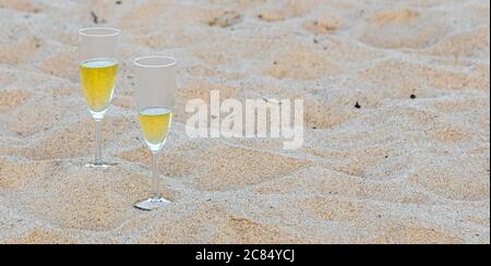 Due bicchieri di champagne seduti nella sabbia su una spiaggia oceanica, Amagansett, NY Foto Stock