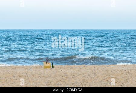 Borsa e una bottiglia di champagne su una spiaggia di Montauk a Montauk, NY Foto Stock