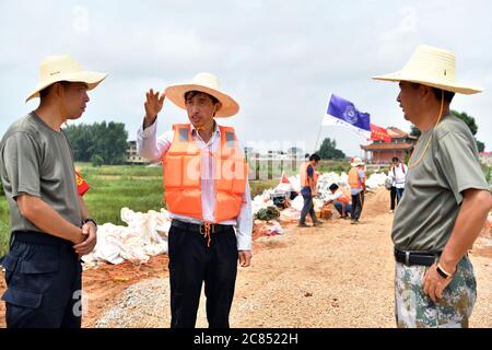 (200721) -- JIUJIANG, 21 luglio 2020 (Xinhua) -- il professor Deng Juzhi (C) comunica con il personale locale di controllo delle inondazioni sulla diga interna del fiume Furong nella città di Furongdun di Jiujiang, nella provincia di Jiangxi, nella Cina orientale, 21 luglio 2020. La diga interna del fiume Furong ha visto continui problemi di tubatura a causa di un gran numero di nidi di formiche in esso, che rappresentano una grave minaccia per la sicurezza dei residenti locali. Credit: Xinhua/Alamy Live News Foto Stock