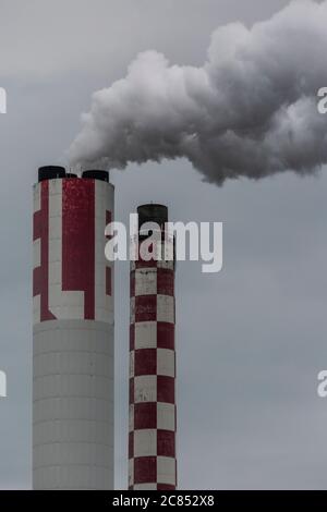 Camini industriali che espellono gas nell'atmosfera Foto Stock