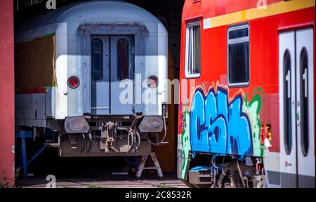 16 luglio 2020, Meclemburgo-Pomerania occidentale, Mukran: I vecchi pullman per passeggeri vengono ricondizionati nell'officina di riparazione della Baltic Port Services GmbH (BPS). Nel workshop, aperto dalla Deutsche Reichsbahn nel 1986, i veicoli ferroviari provenienti dal traghetto ferroviario sono stati ricavati dal largo raggio russo di 1520 millimetri alla normale pista utilizzata nel resto d'Europa. Il laboratorio, che fu ripreso nel 2014 dall'odierna Enon, con sede a Putlitz, Brandeburgo, riconversione vecchi locomotori e carrozze ferroviarie per l'utilizzo da parte di aziende ferroviarie private. Foto: Jens BüŸttner/dpa-Zentra Foto Stock