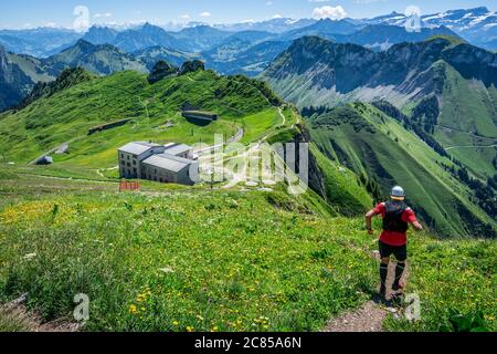 Uomo che inizia una pista discesa in Alpi svizzere e panorama delle montagne durante l'estate in Svizzera Europa Foto Stock