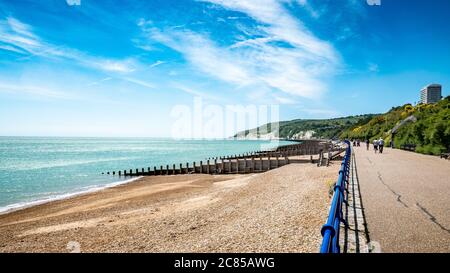 Eastbourne Promenade e South Downs, Inghilterra. Una luminosa vista estiva ad ovest lungo il fronte mare verso le bianche scogliere della costa del Sussex. Foto Stock