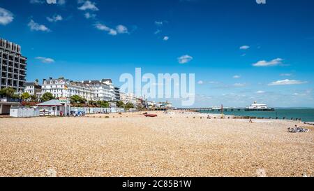 Eastbourne, Sussex, Regno Unito. Una vista estiva della spiaggia nella citta' del Sussex Est sulla costa sud dell'Inghilterra con il distintivo chiosco a banderiera e il molo in vista. Foto Stock