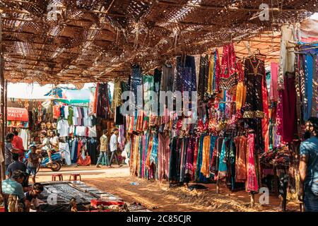 Anjuna, Goa, India. Man Seller vende souvenir e abiti indiani nel mercato di Anjuna. Foto Stock