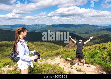 Felice uomo escursionista che festeggia sulla cima della montagna con le braccia in su Foto Stock