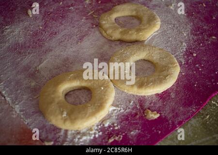 Un primo piano di pasta di ciambelle disposto su un tavolo in cucina Foto Stock