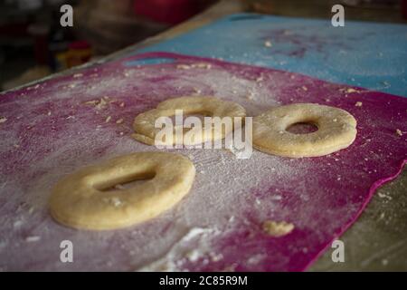 Un primo piano di pasta di ciambelle disposto su un tavolo in cucina Foto Stock