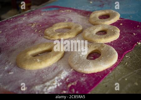 Un primo piano di pasta di ciambelle disposto su un tavolo in cucina Foto Stock