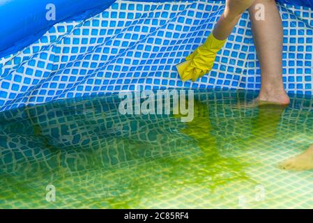 Pulizia piscina gonfiabile in pvc, pulizia della piscina vuota sporca di alghe, concetto di servizio di pulizia. Foto Stock