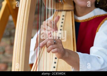 Italia, Lombardia, Crema, Festival medievale, mani della donna che giocano un'arpa Foto Stock