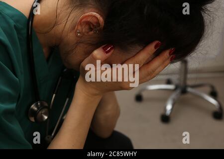 PORT ELIZABETH, SUDAFRICA - 03 luglio 2020: Una dottoressa esausta con la testa in mano. Lavoratori sanitari che sono overworked durante il C Foto Stock