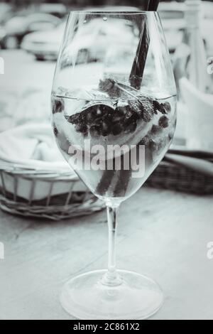 Cocktail estivo con menta, fette di limone e frutti di bosco, bevanda estiva rinfrescante. Cocktail Berry, la bevanda rinfrescante, mojito tonizzato in bianco e nero Foto Stock