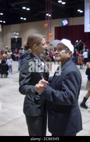 San Antonio, Texas USA, 24 novembre 2005: Senior citizen Dancing with High School JROTC Recruit at the 26th Annual Raul Jiminez Thanksgiving Dinner, dove oltre 25.000 pasti sono serviti il giorno del Ringraziamento per anziani, senzatetto, poveri e sfollati del sud del Texas. ©Bob Daemmrich Foto Stock