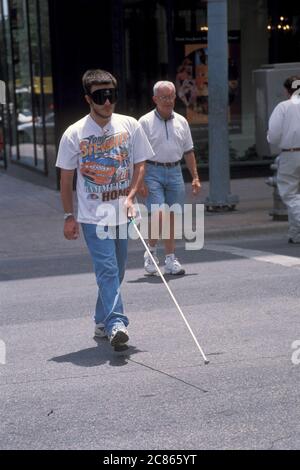 Austin, Texas USA, 2005: Persone con disabilità visive che attraversano la strada con l'assistenza di un bastone da passeggio. ©Bob Daemmrich Foto Stock