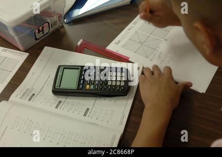 Brownsville, Texas USA, 2 dicembre 2005: Studente alla Lopez High School lavora sui problemi di matematica nella classe Algebra II utilizzando una calcolatrice scientifica portatile. ©Bob Daemmrich Foto Stock