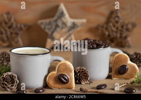 decorazione del tavolo di natale con biscotti di caffè in forma di cuore e chicchi di caffè Foto Stock