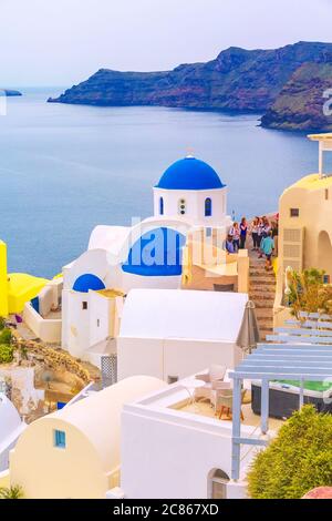 Oia - Santorini, Grecia - 25 Aprile 2019: famosa città, villaggio vista panoramica con blu cupola della chiesa e case colorate Foto Stock