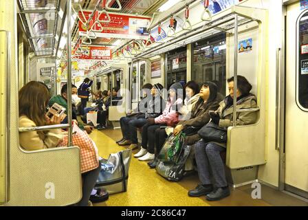 Persone che viaggiano in un'auto metropolitana di Tokyo Foto Stock