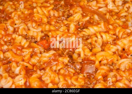 Condire con un condimento di fusilli con carne tritata e salsa di pomodoro con spezie e verdure Foto Stock