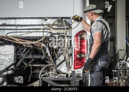 Tecnico di assistenza autobus caucasico negli anni '40 che si trova davanti al veicolo senza motore diesel si prepara per un altro passo. Foto Stock