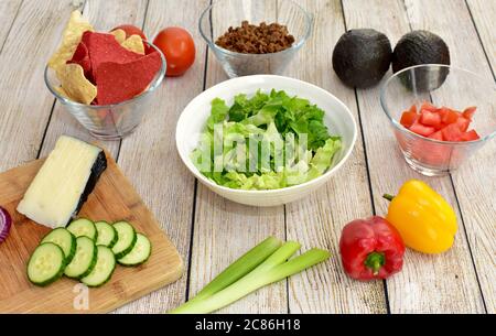 Ingredienti sani pronti per preparare il kit pasto cena di famiglia gourmet insalata taco con verdure fresche raccolte Foto Stock