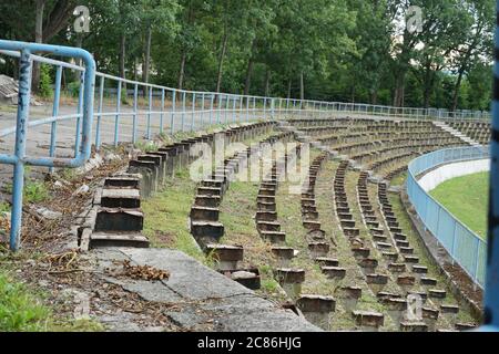 Una tribuna di calcio in sciopero o decaduto in una città provinciale in Europa orientale. I sedili in legno sono stati rimossi perché erano marcio. Foto Stock