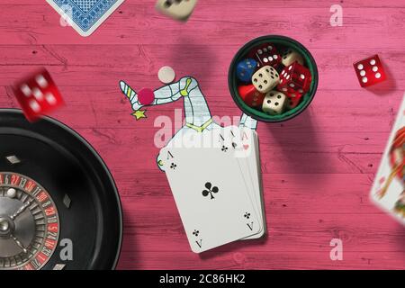 Tema del casinò dell'isola di Man. Assi nel gioco del poker, carte e chip sul tavolo rosso con sfondo bandiera nazionale. Gioco d'azzardo e scommesse. Foto Stock