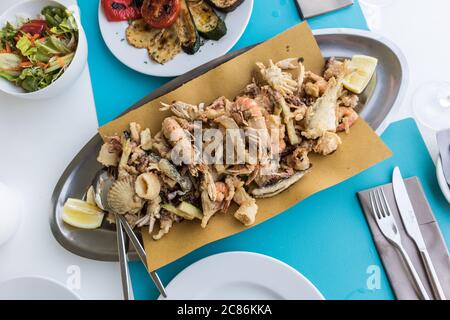 Delizioso piatto di pesce fritto per due in vacanza estiva nel tradizionale ristorante costale croato vicino al mare. Foto Stock
