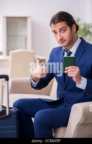 Giovane uomo d'affari con passaporto in preparazione al viaggio Foto Stock