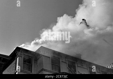 AJAXNETPHOTO. 7 MARZO 1969. SOUTHSEA, PORTSMOUTH, INGHILTERRA. - INCENDIO DELL'HOTEL - VIGILI DEL FUOCO IN CIMA A UNA SCALA GIRADISCHI PARZIALMENTE OSCURATA DAL FUMO, RIVERSA L'ACQUA NEL TETTO DI HEREFORD HOTEL IN KENT ROAD. GLI OCCUPANTI DELL'HOTEL SONO STATI EVACUATI IN MODO SICURO E NON CI SONO STATE VITTIME.PHOTO:JONATHAN EASTLAND/AJAX REF:202206 24 Foto Stock