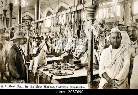 (Capra) Meat Stall - New Market, Calcutta (Calcutta), stato del Bengala Occidentale, India. I due gentiluomini a destra sono chiaramente musulmani e quindi praticano la macelleria Halal. Foto Stock