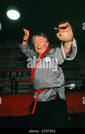 L'attore MacDonald Carey colpisce una posa minacciosa durante un allenamento con un intagliatore marziale. Foto Stock