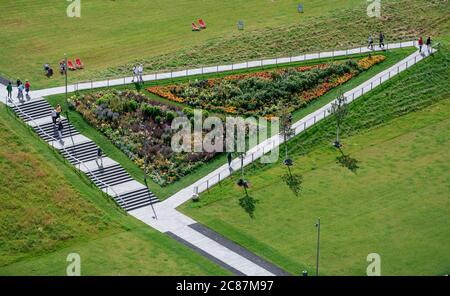 Kamp Lintfort, Germania. 21 luglio 2020. I visitatori camminano lungo un letto fiorito. Lo Stato Horticultural Show Kamp-Lintfort 2020 è il 18 dello stato della Renania Settentrionale-Vestfalia. La città di Kamp-Lintfort organizza lo spettacolo del giardino sul sito di collisione ex Friedrich Heinrich pit. Credit: Fabian Strauch/dpa/Alamy Live News Foto Stock