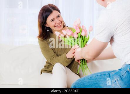 Marito saluto moglie con bouquet di fiori a sorpresa Foto Stock