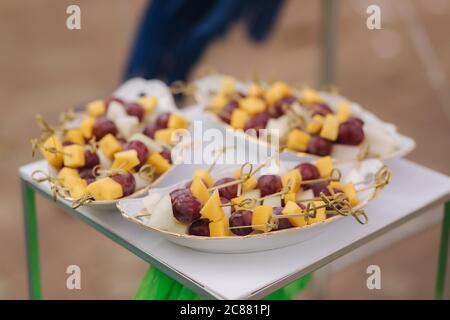 Snack in festa in terrazza. Spiedini con formaggio, uva e melone Foto Stock