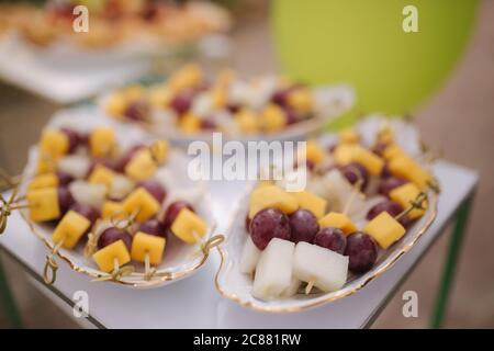 Snack in festa in terrazza. Spiedini con formaggio, uva e melone Foto Stock