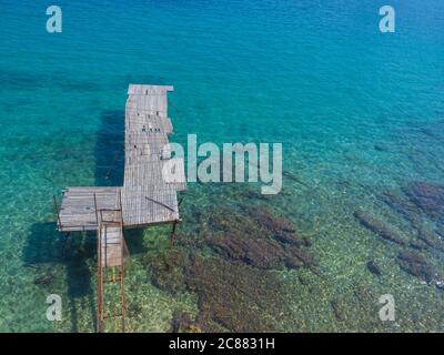 Vista areale sul molo in legno di sabbia con acque turchesi del Mar Ionio, spiaggia di Faliraki, bagni termali di Alecos, isola di Corfù, Grecia Foto Stock