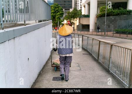 La passeggiata più pulita sulle strade di hong kong in un cappello di bambù tradizionale Foto Stock