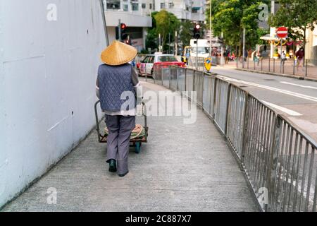 La passeggiata più pulita sulle strade di hong kong in un cappello di bambù tradizionale Foto Stock