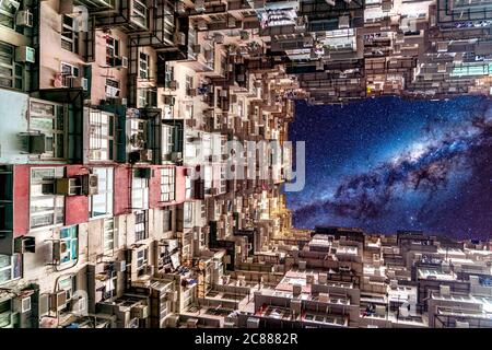 La galassia notturna cielo sopra la Montane Mansion vicino a Tai Koo a Hong Kong. Vecchio edificio retrò sovraffollato Foto Stock