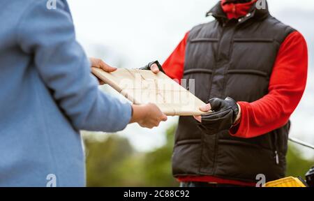 Consegna Courier Guy che dà pacchi a clienti irriconoscibili all'aperto, tagliato Foto Stock