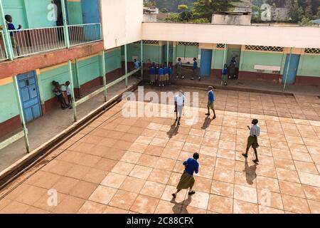 Vista esterna della scuola secondaria con cortile e bambini in uniforme, Nairobi, Kenya Foto Stock