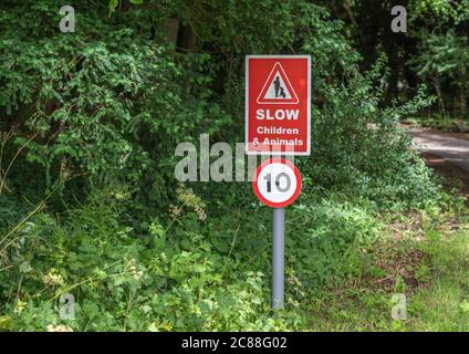 Slow bambini e animali segnale rosso strada con un limite di velocità di 10 Foto Stock