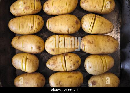 Cibo di patate crude a fette su teglia da forno Foto Stock